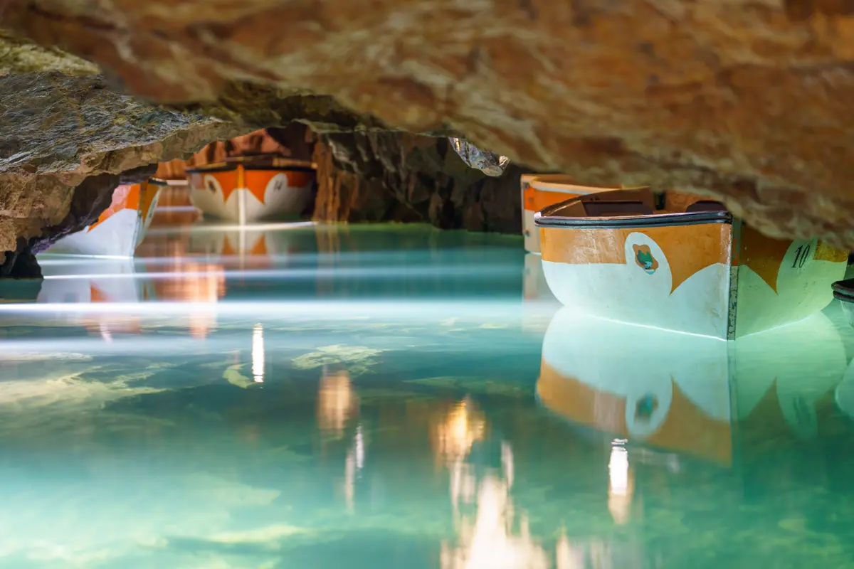 Galería iluminada de las Coves de Sant Josep vista desde la barca durante la visita guiada