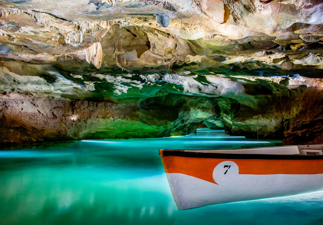 Barcas de la visita guiada navegando por el río subterráneo de las Coves de Sant Josep, La Vall d'Uixó