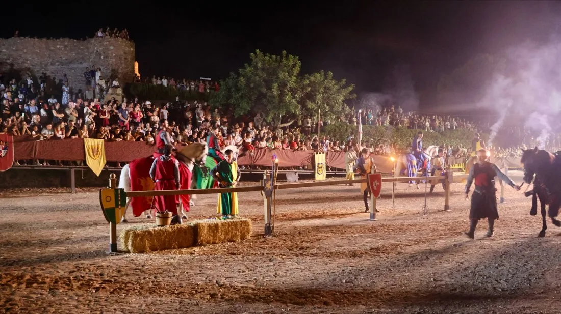 Vista general del torneo medieval nocturno con justas a caballo y grada llena de público en el castillo de Onda