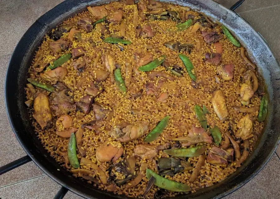 Paella valenciana tradicional cocinada al fuego en Onda