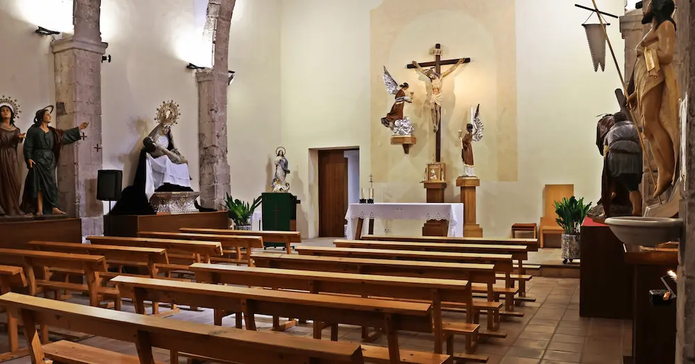 Interior de la Iglesia de la Sangre de Onda, con arcos de piedra, imágenes procesionales y el altar al fondo