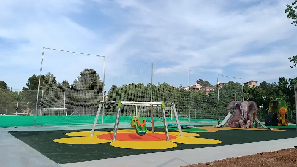 Zona infantil de la MICO Gaming Zone con columpios, figuras de animales y pista deportiva al fondo