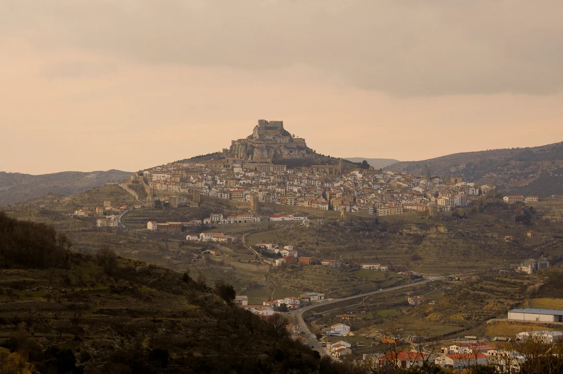 Silueta de Morella al atardecer, castillo y murallas sobre el peñasco de Els Ports
