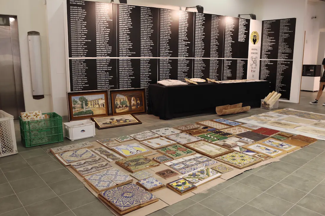 Mural de donantes y piezas cerámicas donadas en el Museu del Taulell de Onda, con azulejos históricos extendidos en el suelo