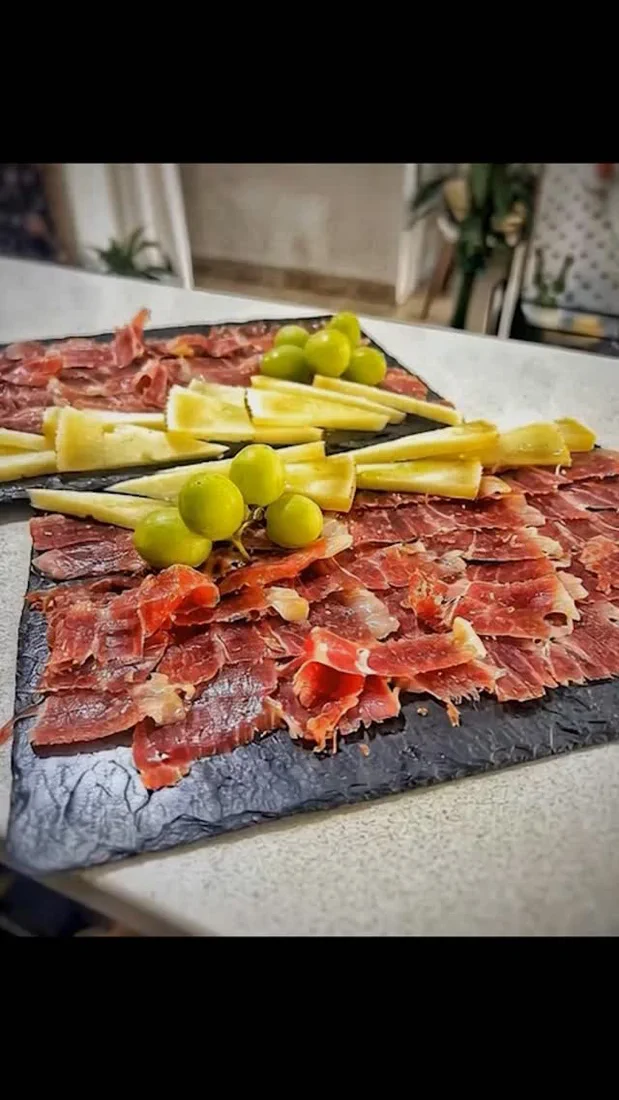 Tabla de jamón ibérico y queso con uvas en Almudí by Iracema