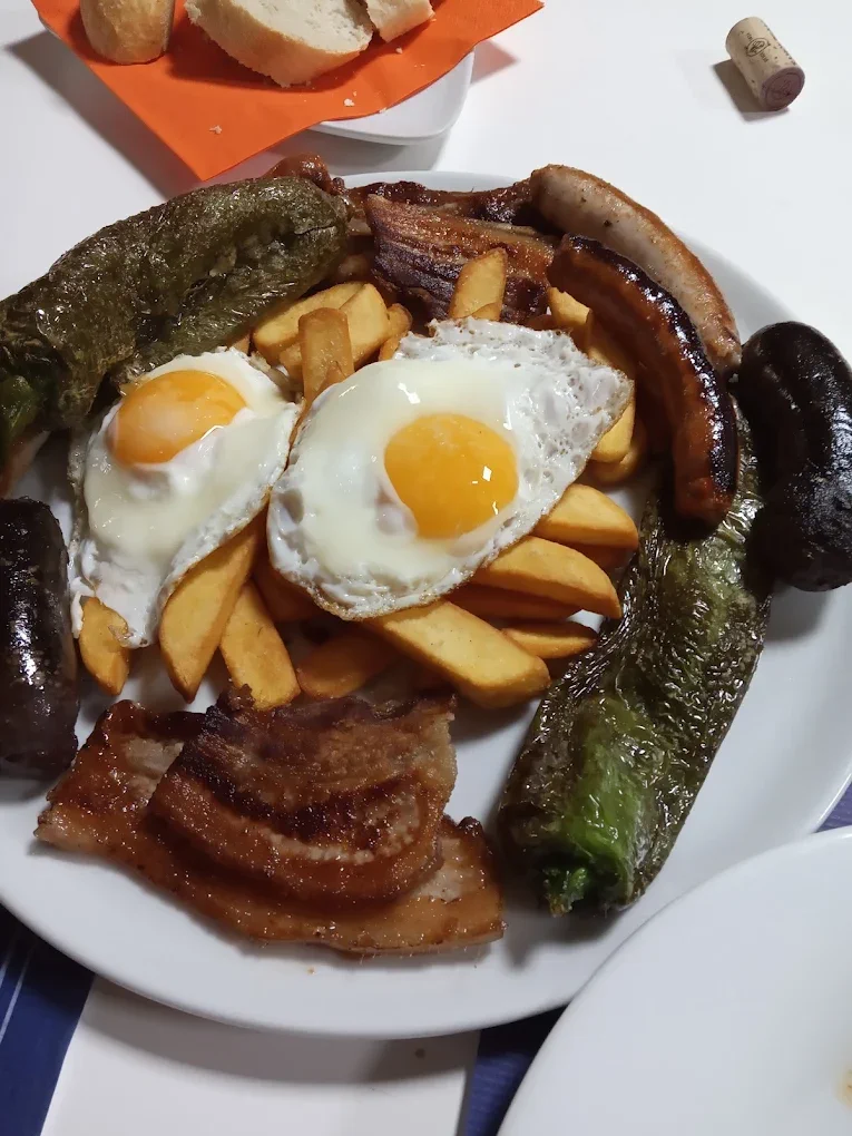 Plato de huevos fritos con longaniza, morcilla, bacon y pimientos verdes