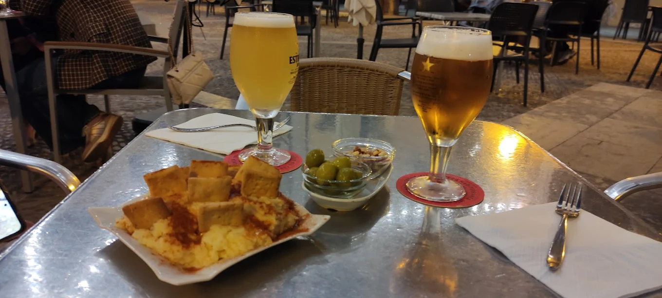 Cañas con bravas y aceitunas en la terraza nocturna