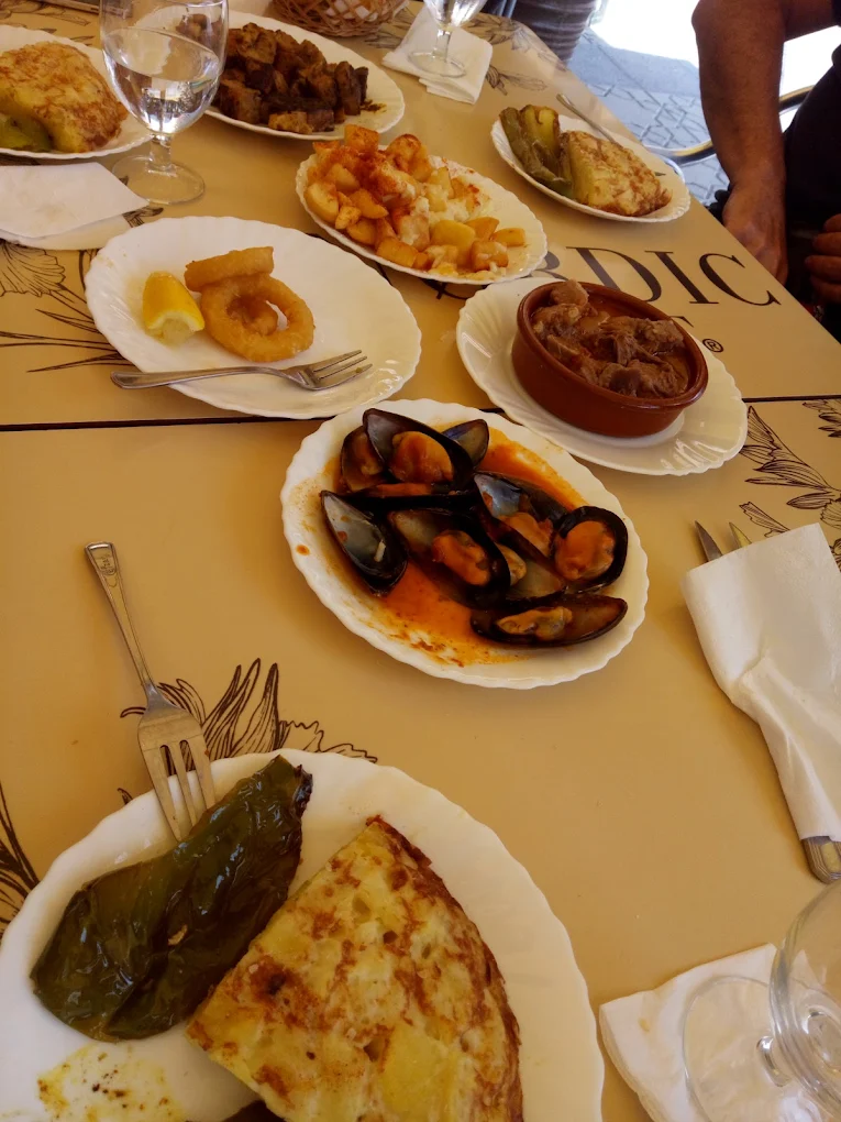 Mesa de tapas variadas en Bar Toga: mejillones, calamares, tortilla y aceitunas