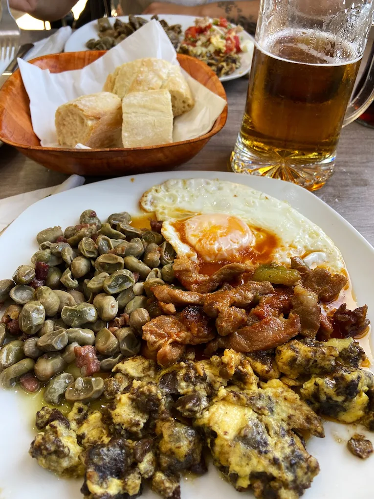 Plato de almuerzo con caracoles, panceta y huevo