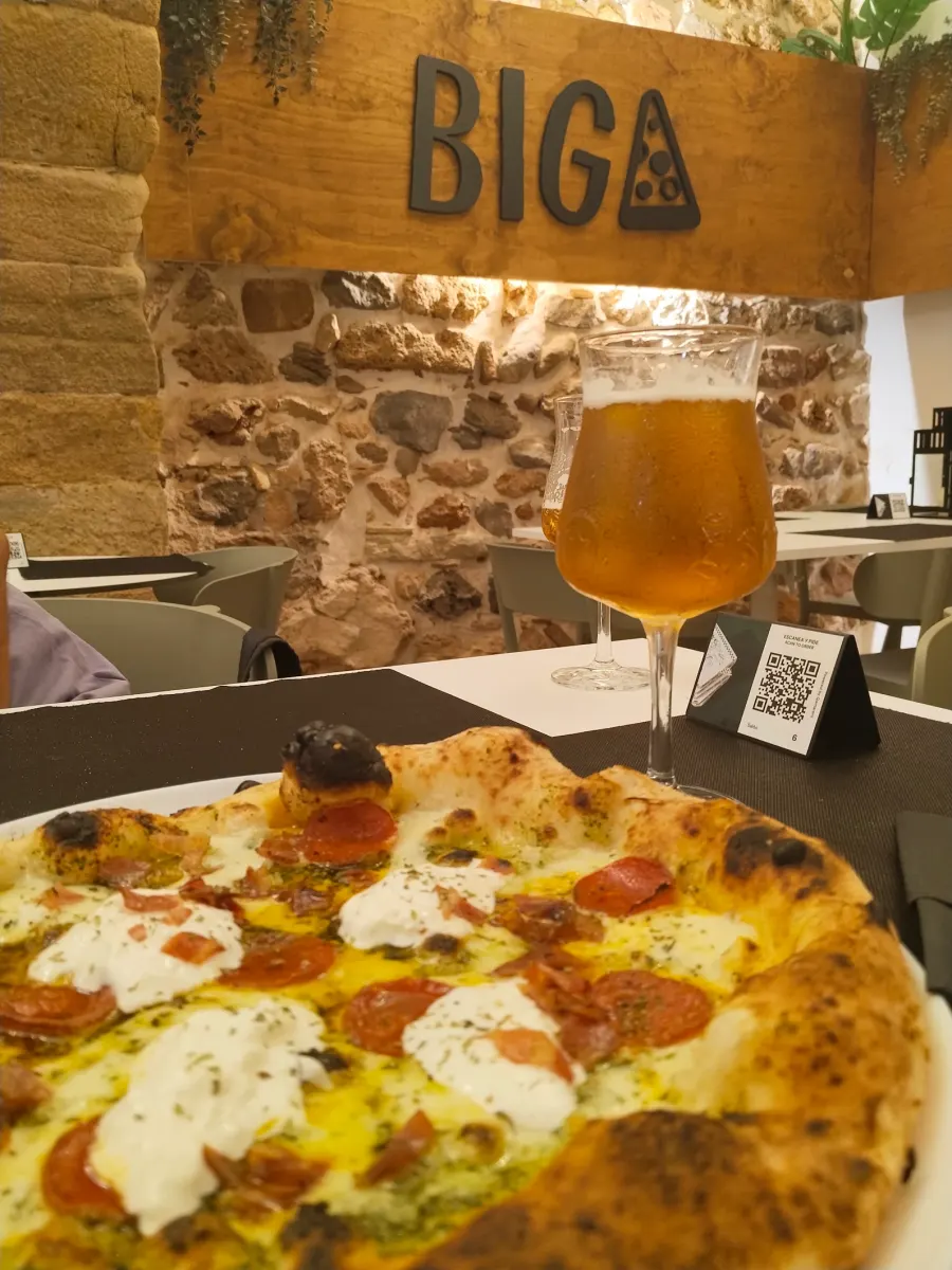 Pizza con burrata y cerveza junto al cartel de madera de BIGA, Onda
