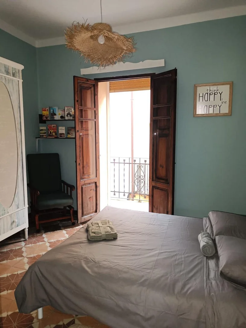 Dormitorio de Casa Almudí con balcón y paredes azules en Onda