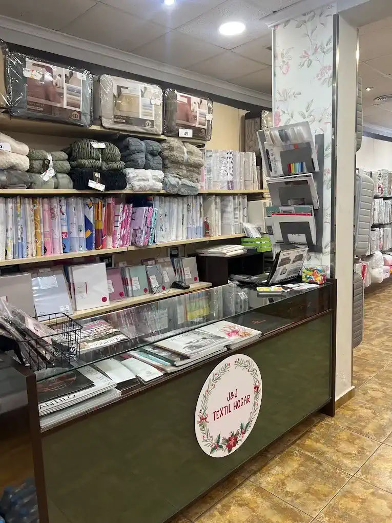 Mostrador interior con logo J&J Textil Hogar y estanterías de ropa de cama