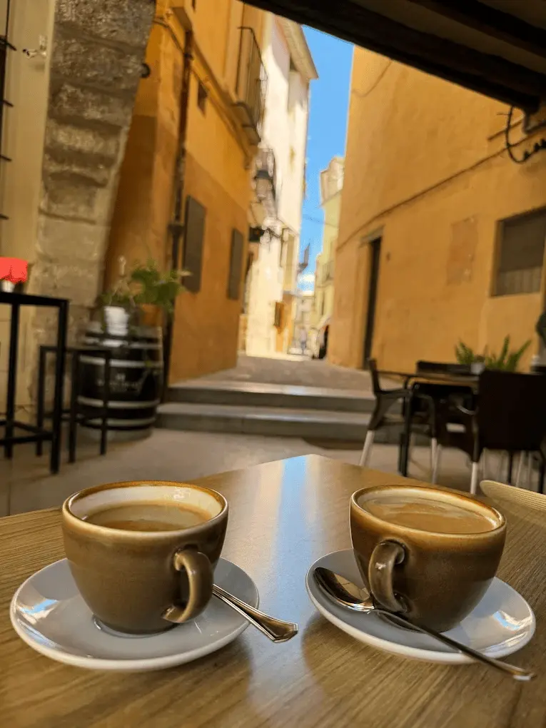 Dos cafés en terraza con vistas al callejón del casco histórico de Onda