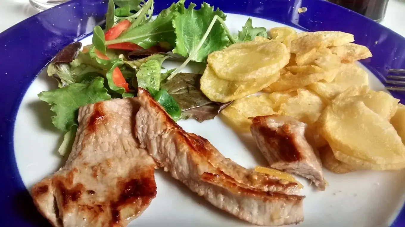 Plato combinado de carne a la plancha con patatas fritas y ensalada en La Cantina