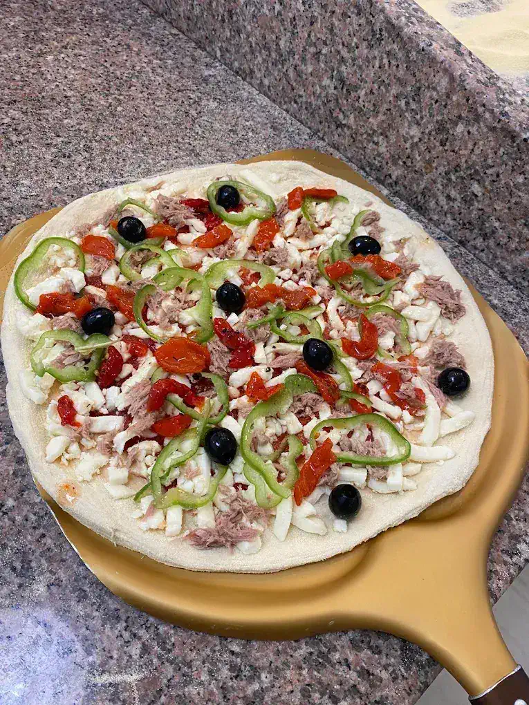 Pizza sobre pala antes del horno en Ohana Pizzeria