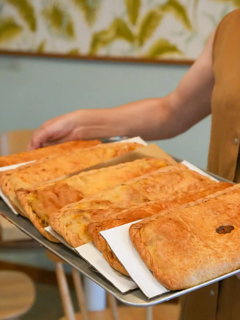 Pastissos salados en bandeja siendo servidos en Castañ, tradición del viernes en Onda