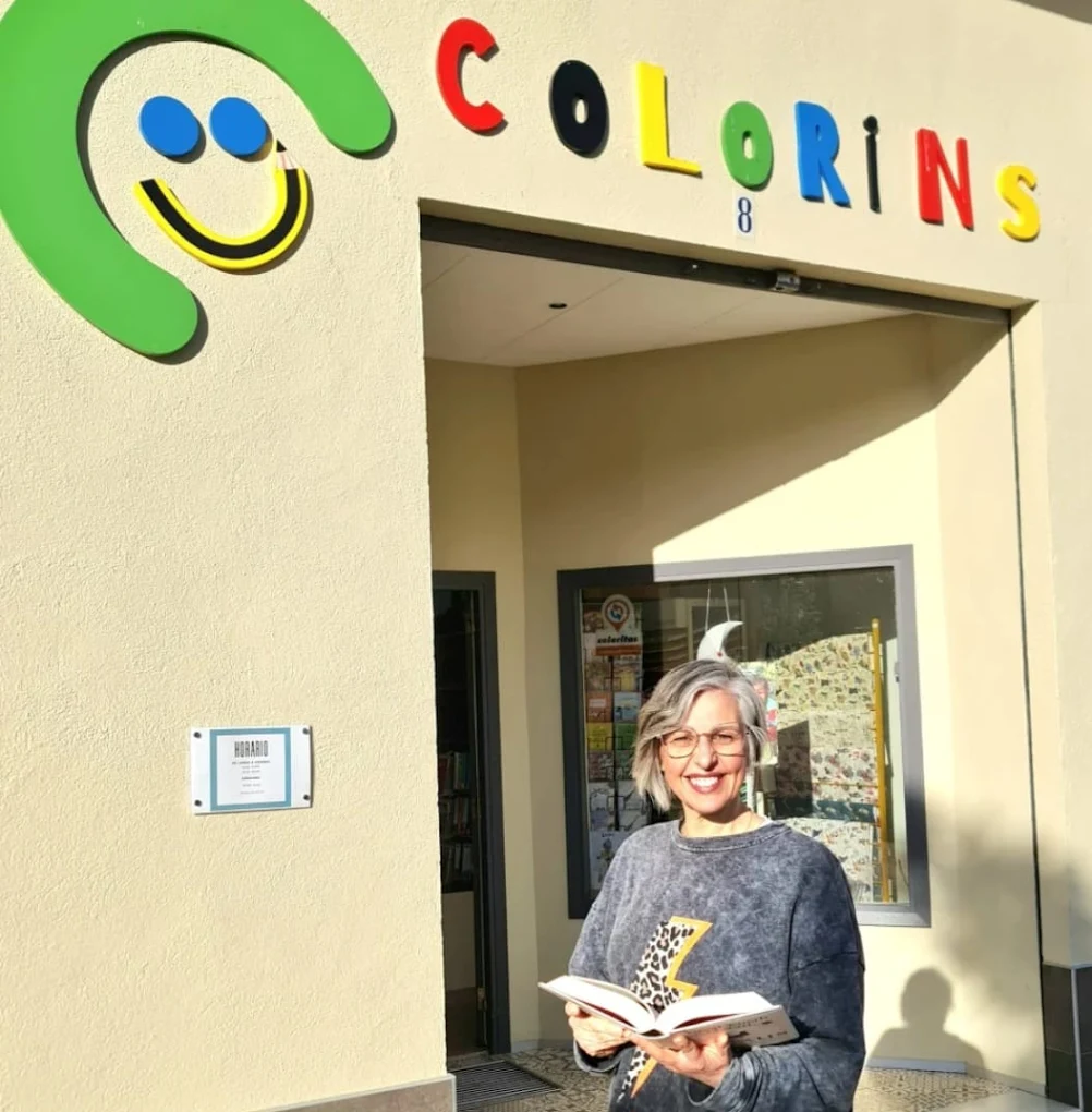 Angélica, propietaria de Colorins, en la fachada de la tienda