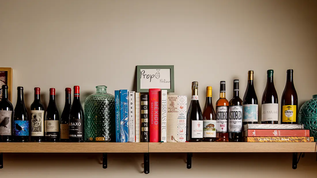 Estantería de vinos y libros de cocina en Propi Restaurant, Onda