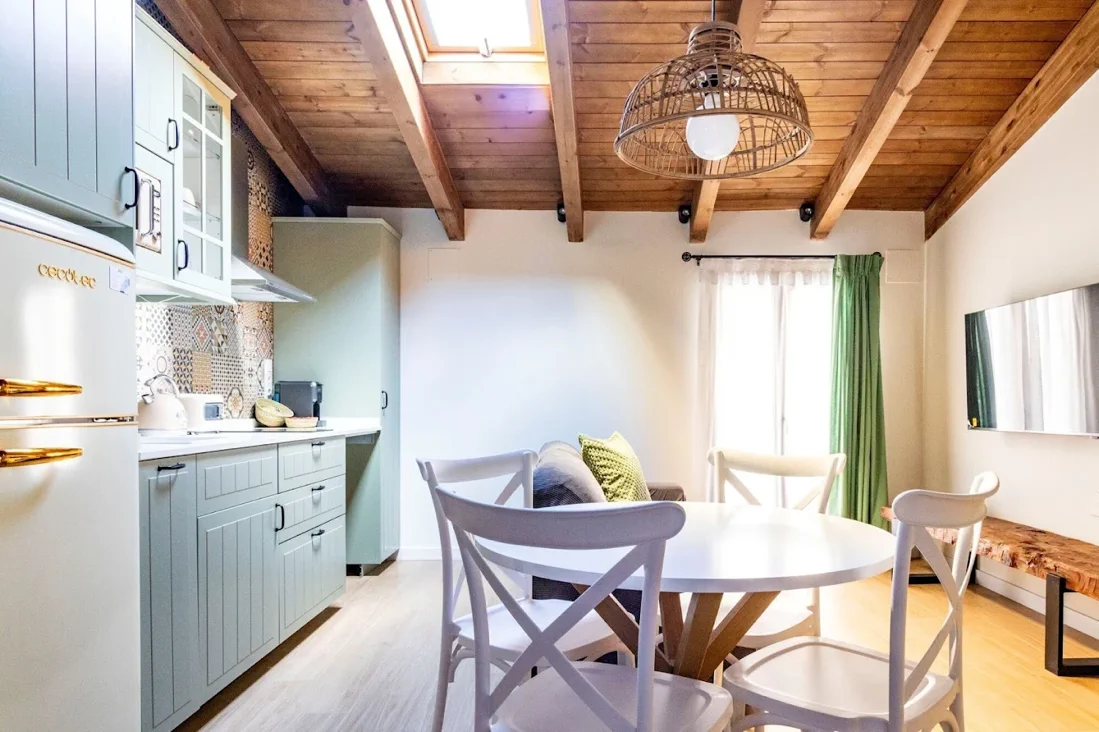 Salón-cocina con vigas de madera y claraboya en Refugi dels Somnis
