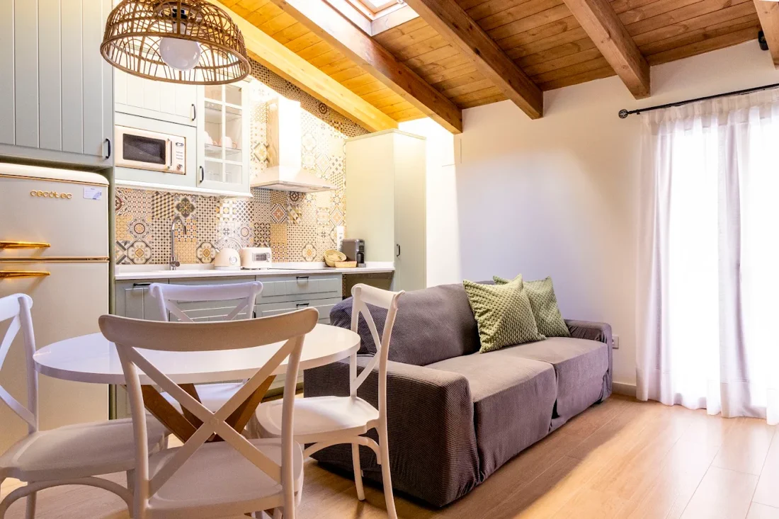 Salón con sofá y cocina de azulejos en Refugi dels Somnis