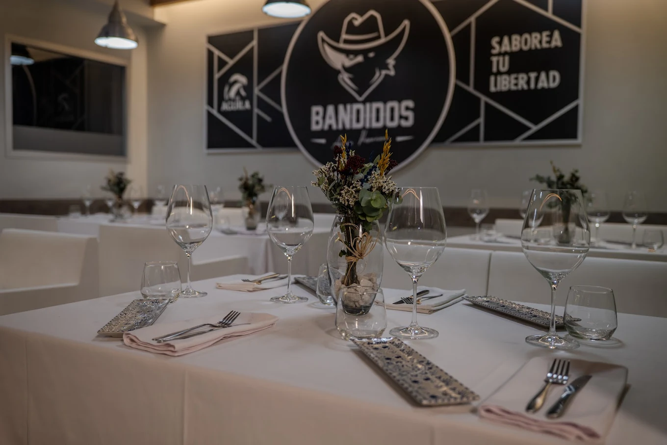 Interior del restaurante Bandidos en Onda con el logo y mesas preparadas