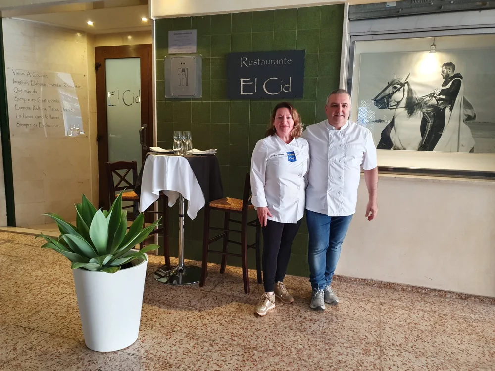 Juan y Gema, propietarios, junto al letrero de la entrada del Restaurante El Cid en el Pasaje Algueró de Onda