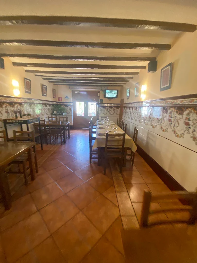 Sala interior con vigas de madera y suelo de barro cocido