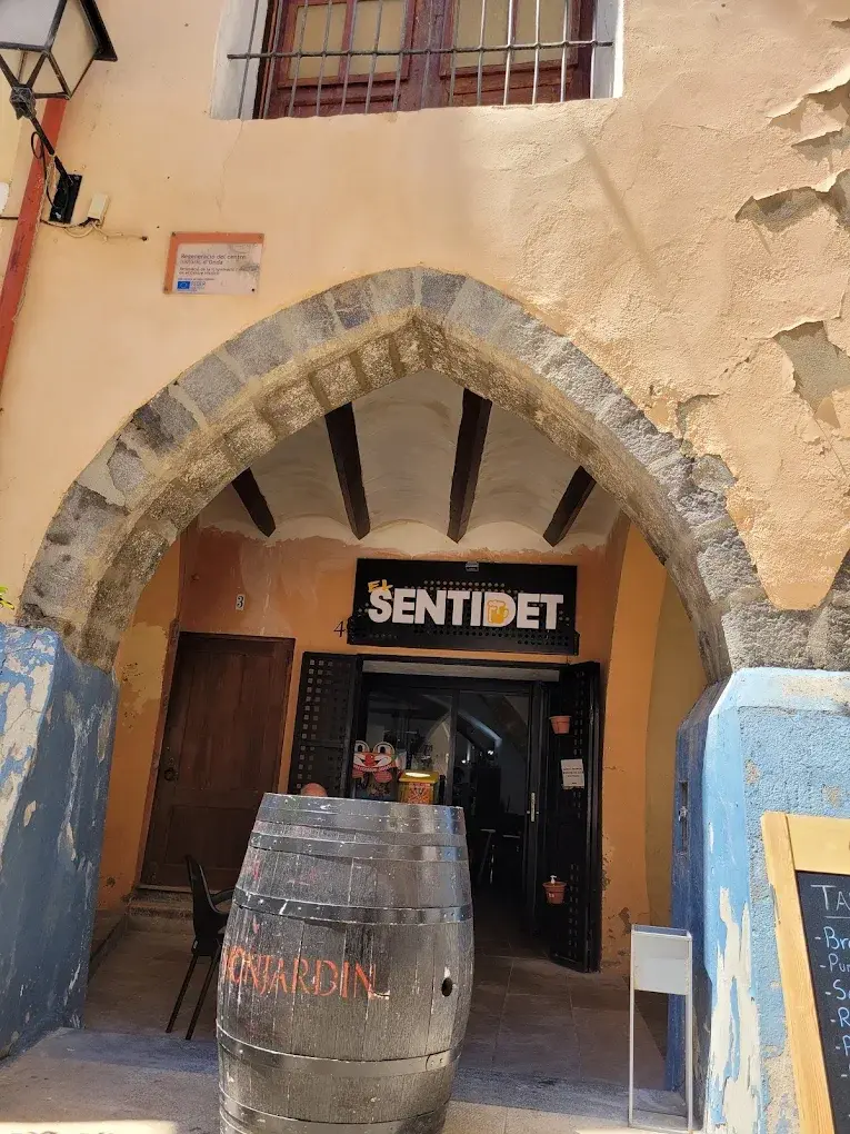 Entrada con arco medieval y cartel de El Sentidet