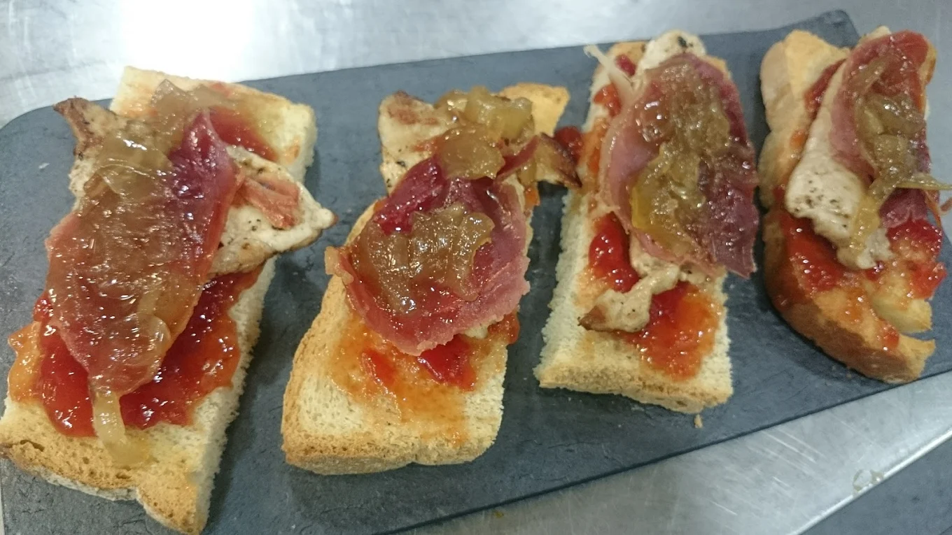 Montaditos de jamón ibérico sobre pizarra en Sis Quarts
