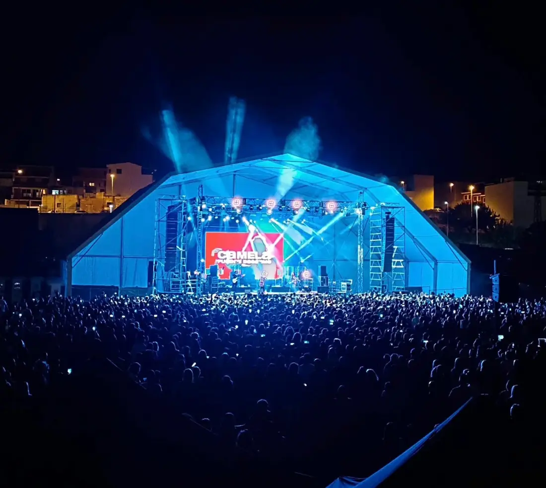 Concierto de Camela de noche en el Festival Onda Flamenca: escenario iluminado bajo la gran carpa con el público llenando el recinto