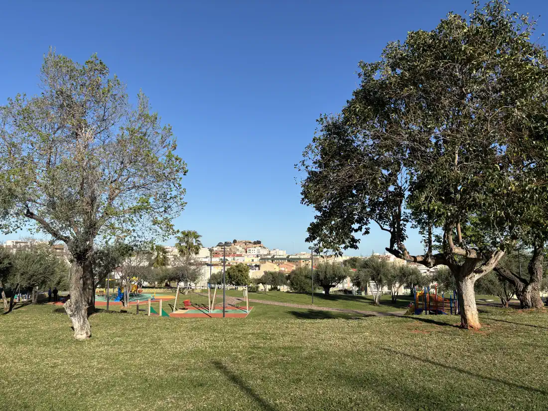 Zona de juegos del Parque de la Cerámica con el castillo de Onda visible al fondo entre los árboles