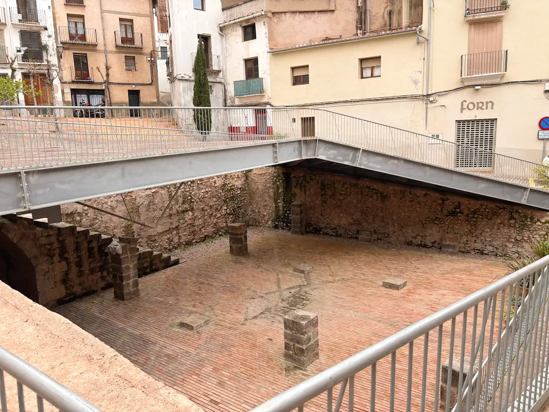 Vista del yacimiento arqueológico de la Plaza de la Sinagoga de Onda con la plataforma metálica elevada y los muros islámicos y góticos excavados
