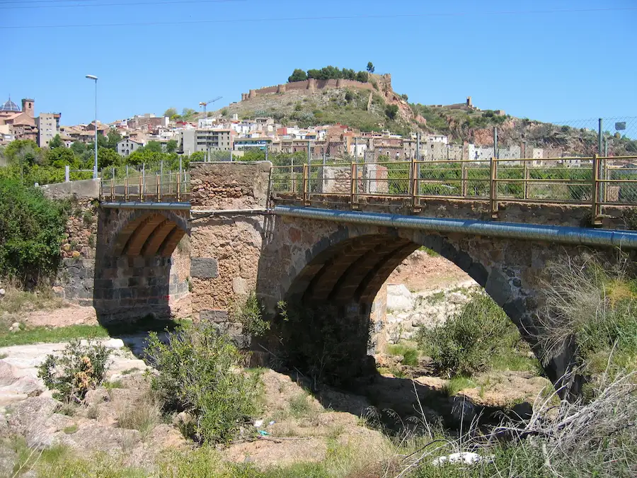 Vista general del puente medieval sobre el río Sonella de Onda con el castillo al fondo